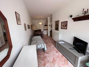 a living room with a tv and a couch at Tenuta Poggio alla Farnia in Fauglia
