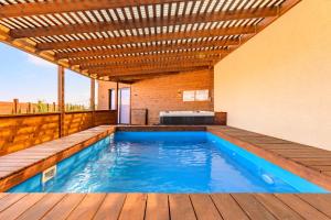 an outdoor swimming pool with a wooden pergola at בקתות שוויצריה הקטנה בכרמל in Haifa