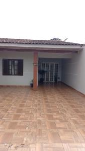 an empty garage with a wooden floor in front of a house at Casa Gil in Foz do Iguaçu