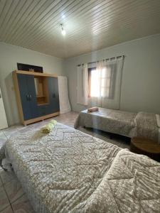 a bedroom with two beds and a window at Casa Gil in Foz do Iguaçu