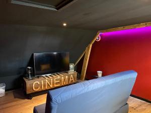 a living room with a couch and a tv at Chambre étape only femme in Pédernec