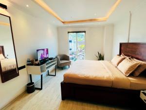 Dormitorio con cama, escritorio y TV en Bed Station 210, en Kandy