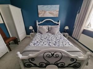 una camera da letto con un letto bianco e pareti blu di Dungarvon House B&B, Exclusive Bookings Only, Hot tub, Garden & Summerhouse, EV Point a Weston-super-Mare