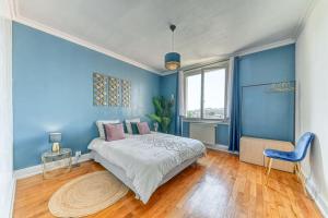 Dormitorio azul con cama y pared azul en L'élégant Zola, en Villeurbanne