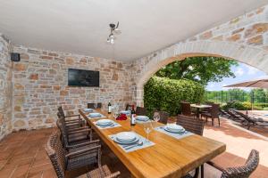 a dining room with a wooden table and chairs at Pilato in Vižinada
