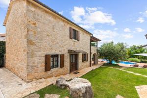 an external view of a stone house with a yard at Pilato in Vižinada