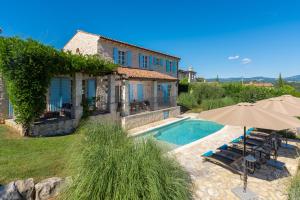 a house with a swimming pool and an umbrella at Sienna in Buzet