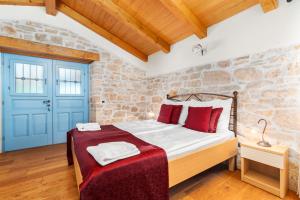 a bedroom with a bed and a brick wall at Pilato in Vižinada +88 photos