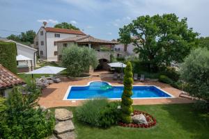 a backyard with a swimming pool and a house at Pilato in Vižinada