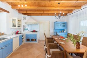 een keuken met blauwe kasten en een houten tafel bij Sienna in Buzet