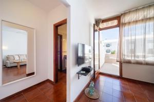 ein Wohnzimmer mit einem großen Fenster und einem TV in der Unterkunft Mafalda's Retreat in Costa Teguise