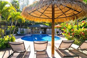 um guarda-sol e duas cadeiras e uma piscina em K B M Resorts- KGV-16T4 Beautiful 1Bd, sweeping ocean views, remodeled, oversized layout em Kapalua