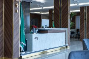 an office lobby with a reception desk and chairs at أزهار النرجس للشقق الفندقية in Umm al Khashab