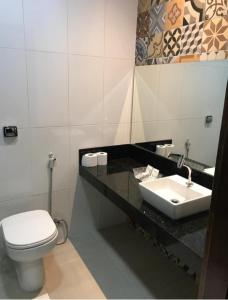 a bathroom with a toilet and a sink at Hotel Vilas in Salinópolis