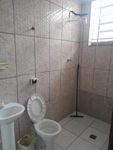 uma casa de banho com um chuveiro, um WC e um lavatório. em Pousada Vitória em Aparecida