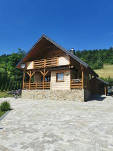 a large wooden cabin with a stone driveway at Beskidzkie Zacisze in Uście Gorlickie