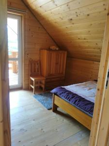 a bedroom with a bed in a log cabin at Beskidzkie Zacisze in Uście Gorlickie