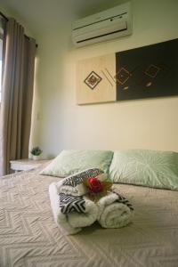 Un dormitorio con una cama con una flor. en Para Vos y Porque Si, en Morro de São Paulo