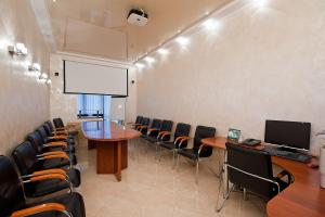 une salle de conférence avec des chaises, une table et un écran dans l'établissement Yug Hotel, à Krasnodar