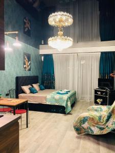Schlafzimmer mit einem Bett und einem Kronleuchter in der Unterkunft New Star in Tbilisi City