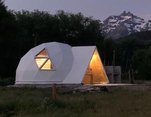 una pequeña casa blanca con una ventana en un campo en Nomade Patagonia Glamping & Domos en Trevelín