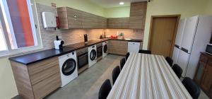 a kitchen with washing machines and a counter with chairs at Alojamento Monte dos Patos in Setúbal