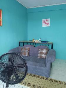Sala de estar azul con sofá y ventilador en The Couples Inn, en Montego Bay