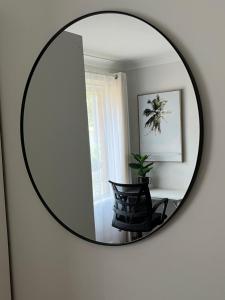 een spiegel aan een muur met een stoel in een kamer bij Perfectly located house with a big backyard. in Castle Hill