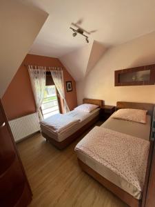 a bedroom with two beds and a window at Apartament nad Zatoką Pucką in Swarzewo