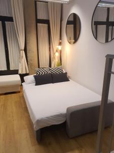 um quarto com uma grande cama branca e um espelho em ESPACIO19 em Córdoba