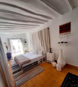 a white bedroom with a bed and a window at STUDIO LOFT MEDINA AVEC TERRASSE in Marrakech