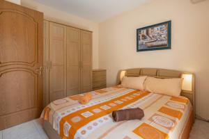 - une chambre dotée d'un lit avec une couverture orange et blanche dans l'établissement Adorable Seaview apt at St Paul's Bay, à San Pawl il-Baħar