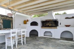 Agios GeorgiosにあるVilla Peristeriのキッチン(暖炉、テーブル、椅子付)