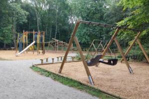 un parque infantil vacío con columpios en un parque en Ramblers Rest en Meopham