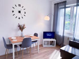 ein Esszimmer mit einem Tisch und einer Uhr an der Wand in der Unterkunft Zwei Apartments für Gruppen - Phantasialand, Köln, Bonn in Brühl
