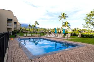 a swimming pool with chairs and palm trees at K B M Resorts- NAP-C37 Gorgeous 2Bed2Bath ocean view, easy access to parking, pool and beach in Kapalua