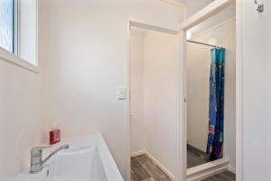 La salle de bains est pourvue d'un lavabo et d'un miroir. dans l'établissement Lakeside Escape - Motuoapa Holiday Home, à Turangi