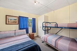 Un dormitorio con dos literas y una ventana. en Lakeside Escape - Motuoapa Holiday Home, en Turangi