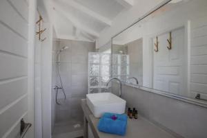 a white bathroom with a sink and a mirror at Villa Branca - Les Terres Basses in Marigot