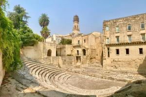 an ancient amphitheater in front of a building at Tyche Suite Luxury in Lecce