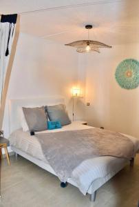 a bedroom with a large bed with a light fixture at Appartement Seacret in Baie Nettle
