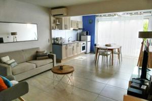 ein Wohnzimmer mit einem Sofa und einem Tisch in der Unterkunft Appartement Seacret in Baie Nettle