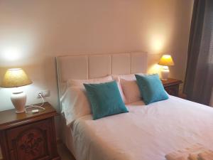 - une chambre avec un lit blanc et 2 oreillers bleus dans l'établissement CAN PLANAS Soleado, amplio con vistas y parking, à Sant Joan de les Abadesses