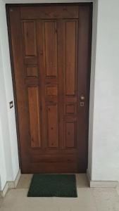 uma porta de madeira num corredor com um tapete verde em CONDOMINIO MAURIZIO A MARE em Scerne