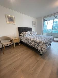 ein Schlafzimmer mit einem Bett, einem Tisch und einem Stuhl in der Unterkunft 2 dormitorios a pasos de la CLC in Santiago