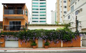 um edifício com flores roxas ao lado em Villa Di Loire no Balneário Camboriú