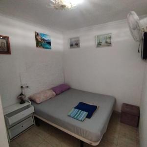 een kleine slaapkamer met een bed en een dressoir bij Relax Playa Ingles in Playa del Inglés