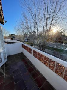 Una cerca blanca con un árbol encima. en VIRAMAR en Alvorada en Barra del Chuy