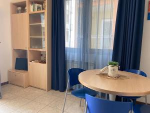 uma mesa e cadeiras azuis num quarto com uma janela em Cometa Beach House em Chioggia