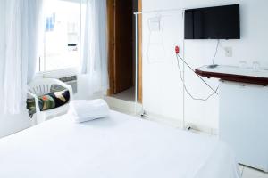 um quarto branco com um lavatório e um espelho em Villa Di Loire no Balneário Camboriú